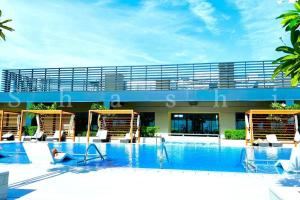 a large swimming pool with chairs and a building at The Shrashi Suites, Dubai Creek Harbour - Paradise on the Island with Dubai Skyline & Burj Khaleefa View in Dubai
