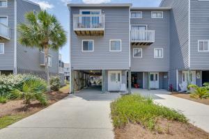an apartment building with a palm tree and a sidewalk at Cape San Blas Townhome with Beach Essentials! in Oak Grove