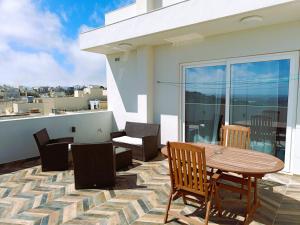 d'une terrasse sur le toit avec une table et des chaises. dans l'établissement Two bedroom loft apartment with outdoor area, served with lift, à Rabat
