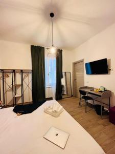 a bedroom with a bed and a desk and a television at A Pisa con amore in Pisa