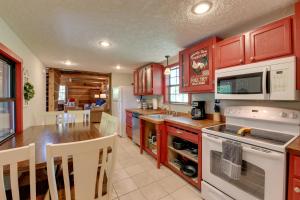 een keuken met rode kasten en een witte kookplaat bij Relaxing Cosby Cabin with Fire Pit and Covered Porch! in Cosby