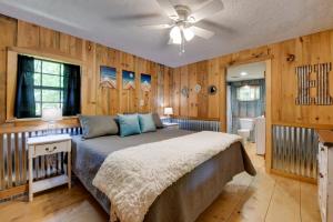een slaapkamer met een bed in een kamer met houten wanden bij Relaxing Cosby Cabin with Fire Pit and Covered Porch! in Cosby
