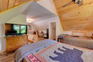 een slaapkamer met 2 bedden en een flatscreen-tv bij Relaxing Cosby Cabin with Fire Pit and Covered Porch! in Cosby