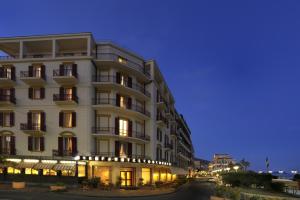 a large white building at night at Hotel Europa & Concordia in Alassio