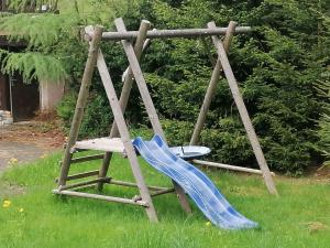 um parque infantil com um escorrega azul na relva em Hotýlek na Mýtě em Harrachov