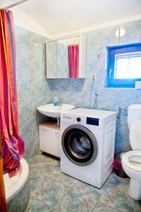 uma casa de banho com uma máquina de lavar roupa e um lavatório em Radeki polje 50 em Loborika