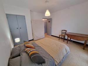 a bedroom with a bed and a table and a desk at Maison avec extérieur dans un village provençal in Saint-Romain-en-Viennois