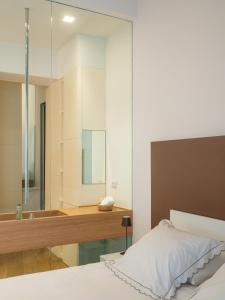 een slaapkamer met een bad, een bed en een spiegel bij Torretto 14 in La Spezia +25 foto's