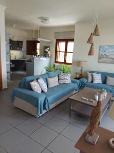 a living room with a blue couch and a table at Eolia apartment with panoramic Chania view in Chania Town