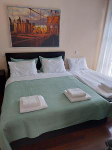 a large bed with two white towels on it at Eolia apartment with panoramic Chania view in Chania Town