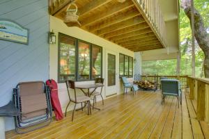 a porch with chairs and a table on a deck at Charming and Secluded Riverside Cabin and 3 Decks in North Vernon