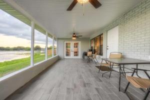 um alpendre coberto com uma mesa, cadeiras e janelas em Lovely Lakefront Home with Grill 7 Mi to Legoland! em Winter Haven