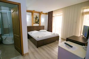 una camera d'albergo con letto e bagno di Vila Victory a 2 Mai