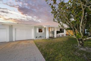 una casa blanca con un árbol en el patio en Lovely Lakefront Home with Grill 7 Mi to Legoland!, en Winter Haven