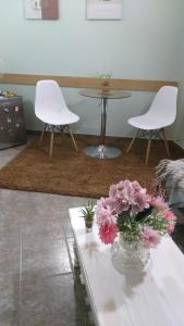 two white chairs and a table and flowers on a table at Saiyú Aeropuerto in Luque