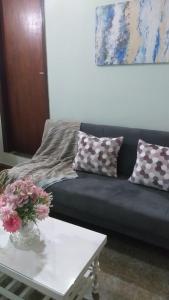 sala de estar con sofá negro y mesa blanca en Saiyú Aeropuerto, en Luque