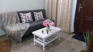 a living room with a couch and a table with flowers at Saiyú Aeropuerto in Luque