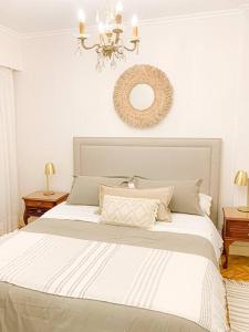 um quarto com uma grande cama branca e um lustre em jh - Creado como un Hotel Boutique em Buenos Aires