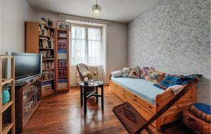 uma sala de estar com um sofá e uma televisão em 4 Bedroom Beautiful Home In Molan-sur-mer em Moëlan-sur-Mer