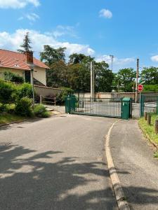 um portão na berma de uma estrada ao lado de uma casa em APPARTEMENT SPACIEUX AVEC BALCON em Saint-Fons