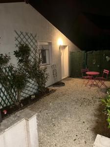 eine Terrasse am Abend mit einem Tisch und Stühlen in der Unterkunft Maison studio Le bois fleuri in Croissy-Beaubourg