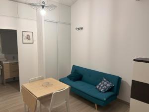 a living room with a blue couch and a table at Maison studio Le bois fleuri in Croissy-Beaubourg