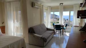 un soggiorno con divano, tavolo e finestre di VISTA PLAYA a Algarrobo-Costa