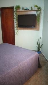 a bedroom with a bed and a tv on a wall at Saiyú Aeropuerto in Luque