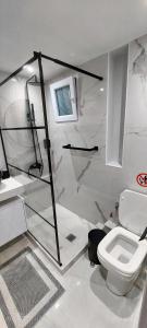 a white bathroom with a toilet and a sink at Monastiraki Heart - Luxury Apartment Athens in Athens