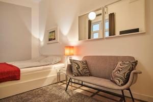 Super Central Studio Apartment - with balcony في بودابست: غرفة نوم بسرير وكرسي ومرآة
