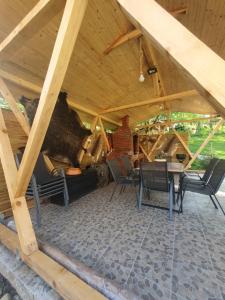 a room with a wooden roof with chairs and a table at Cabana de Vis Valea Prahovei - ciubăr și saună la munte in Talea