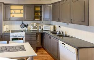 uma cozinha com armários cinzentos e electrodomésticos brancos em Gorgeous Home In Svingvoll With Wifi em Svingvoll