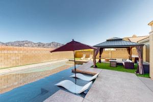 a pool with two lounge chairs and an umbrella at Lemmon Vista in Oro Valley