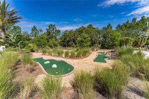 un parcours de golf sur le sable avec des arbres et de l'herbe dans l'établissement Pool Home Champions Gate Area with Resort Amenities Next to Disney, à Davenport