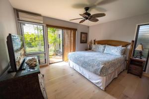 a bedroom with a bed and a ceiling fan at Ekolu 1403 in Wailea +36 photos