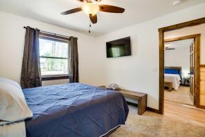 a bedroom with a blue bed and a ceiling fan at Vacation Rental Cabin Near Lake Arbutus! in Hatfield