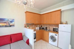 a kitchen with a couch and a white refrigerator at Dina's apartment in Iraklitsa in Iraklitsa