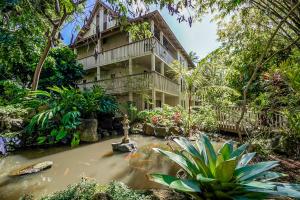 une maison avec un étang en face de celle-ci dans l'établissement Waikomo Stream Villas 322, à Koloa