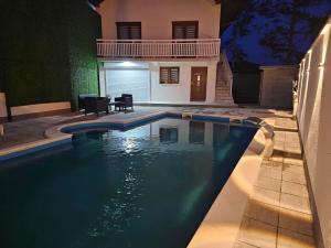 a swimming pool in front of a house at night at Top Holiday Kuca sa bazenom in Lukavac