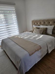 a large bed in a bedroom with a large window at Top Holiday Kuca sa bazenom in Lukavac