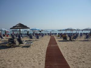 einen Fußweg am Strand mit Stühlen und Sonnenschirmen in der Unterkunft Hotel Miramare - Silvi Marina in Silvi Marina