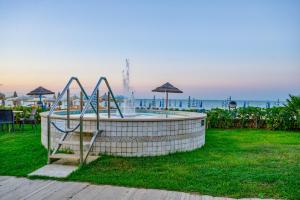 een zwembad met een glijbaan in het gras naast de oceaan bij Hotel Miramare - Silvi Marina in Silvi Marina