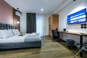 a hotel room with a bed and a desk and a tv at CASA DIVINUS SUITES in Athens
