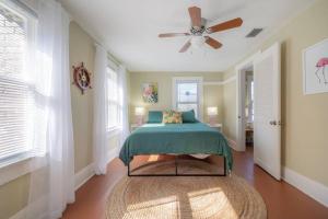 een slaapkamer met een bed en een plafondventilator bij Serene Beachy Bungalow with Large Screened Porch! in Tampa