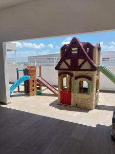 een speeltuin met een huis en een glijbaan bij Apartamento Santo Domingo Este in Mendoza