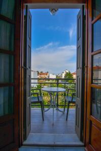 an open door to a balcony with a table at Chrys Marie Studios in Iraion