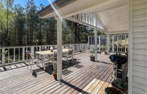 una terrazza in legno con tavolo e griglia di Stunning Home In Nex With Kitchen a Spidsegård