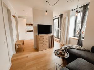 a living room with a television on a wooden dresser at Beautiful Seaside apartement Albatross 23 in Ķesterciems
