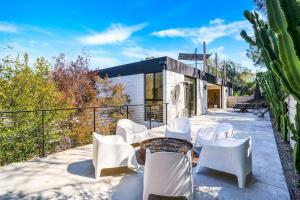 a group of white chairs and a table on a patio at Experience Eco-Luxury at its Finest - Centrally Located Clea House in San Diego! in San Diego