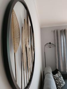 un espejo con plumas en una pared junto a un sofá en Mar à Vista Algarve Summer, en Portimão